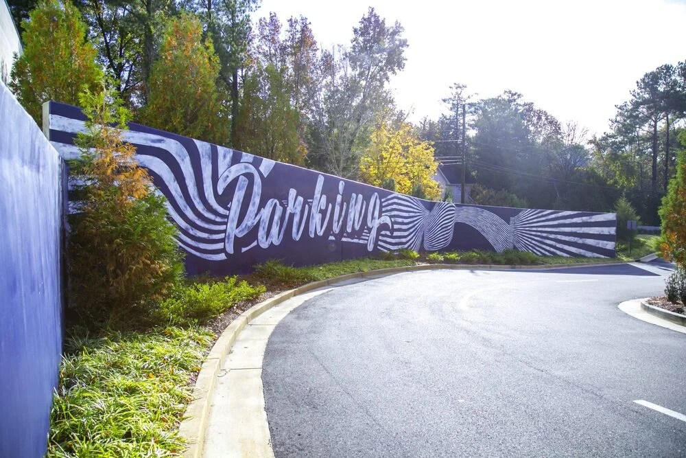 Hand-painted mural on a parking structure in Atlanta, GA. Detailed cityscape.